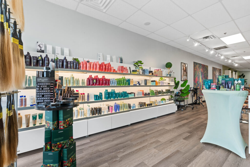 - The Color Bar, TX A well-lit salon displays shelves of haircare products, including shampoos, conditioners, and styling items for Hair Color and Balayage, all arranged by color along one wall. - The Color Bar, TX