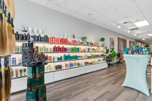 - The Color Bar, TX A well-lit salon displays shelves of haircare products, including shampoos, conditioners, and styling items for Hair Color and Balayage, all arranged by color along one wall. - The Color Bar, TX