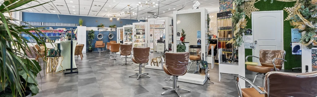- The Color Bar, TX Modern hair salon interior with brown salon chairs, large mirrors, and styling stations. The bright space features plants, decorative accents, and a display of hair products—perfect for your next haircut or balayage service. - The Color Bar, TX