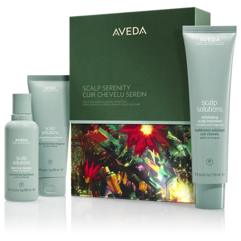 - The Color Bar, TX Experience radiant Winter Hair Rituals with the Aveda Scalp Solutions product set, featuring a spray, shampoo, and scalp treatment displayed in front of a decorative green and floral box—perfect for a New Year refresh. - The Color Bar, TX