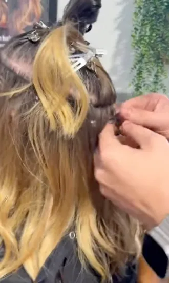 - The Color Bar, TX A stylist attaches Vomor hair extensions Texas to the back of a person’s head using small clips; the person’s real hair is sectioned and pinned up for damage-free extensions. - The Color Bar, TX