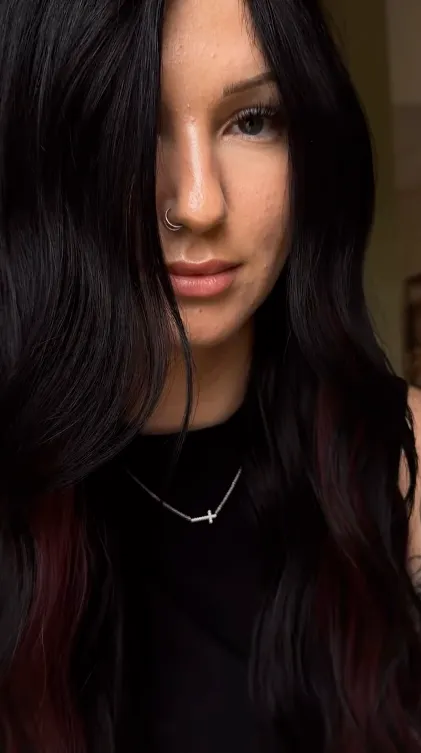 - The Color Bar, TX Woman with long dark hair and a nose ring, wearing a black top and a necklace, looks directly at the camera with a neutral expression—her style hinting at the expertise of an Aveda hair color or grey coverage salon. - The Color Bar, TX